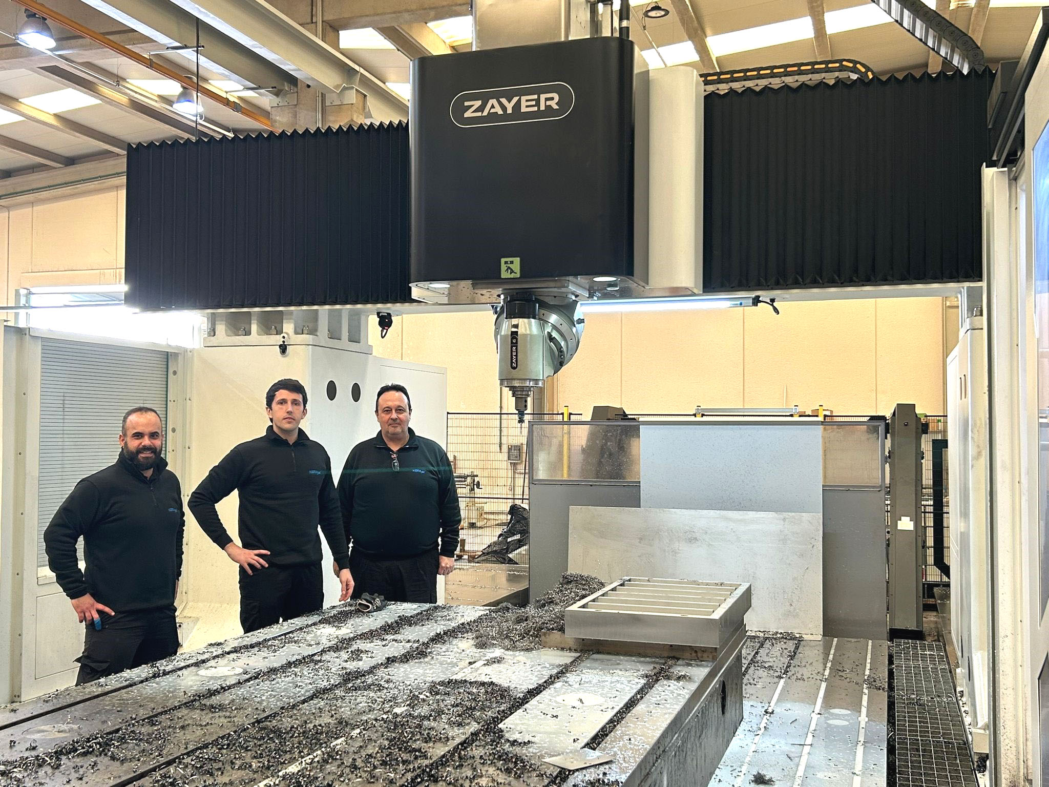 Operators standing next to a Zayer ALTEA 8000 large-capacity, gantry-type milling machine