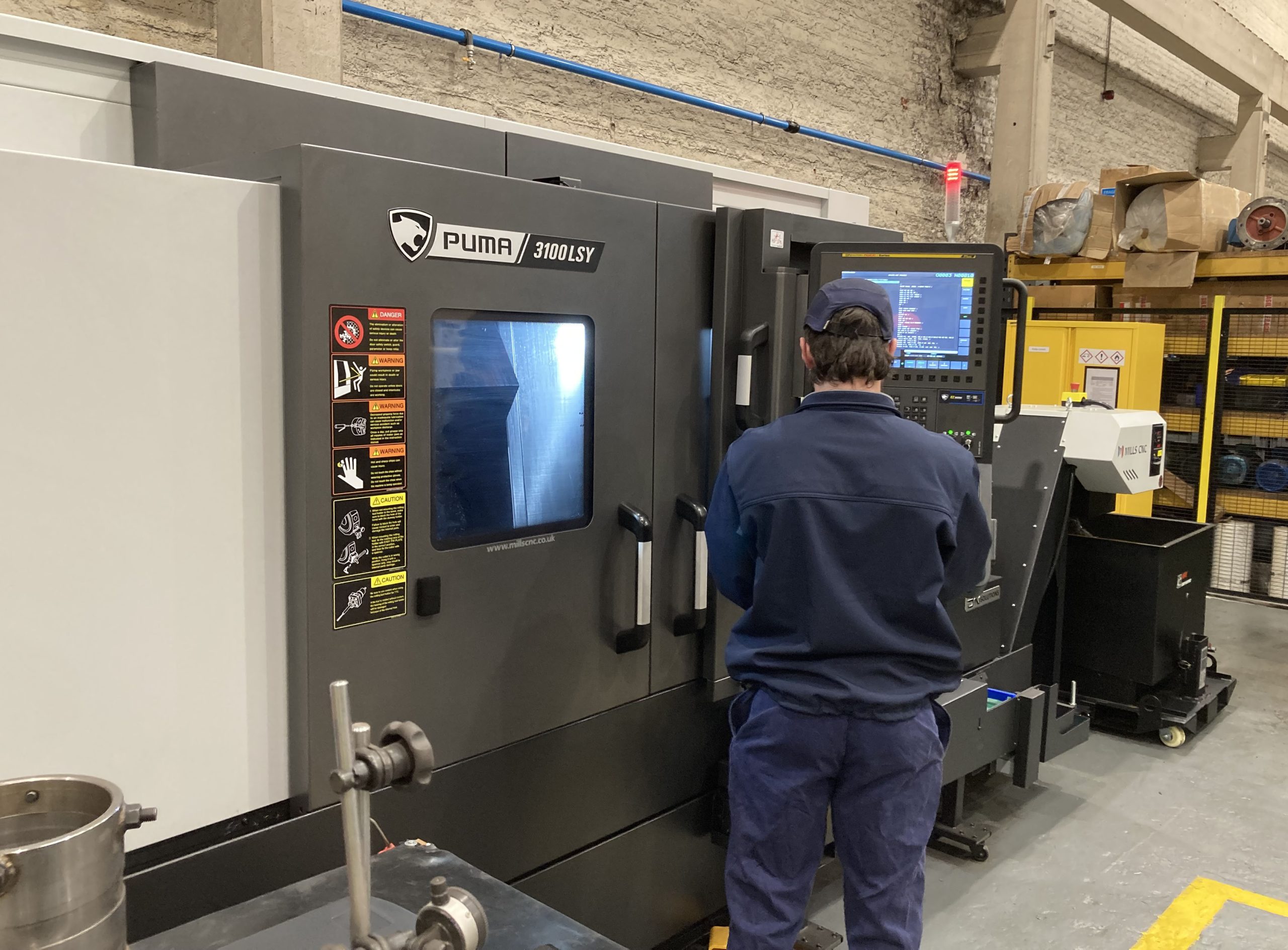 An operator at a DN Solutions Puma 3100LSY Horizontal Single Turret Lathe